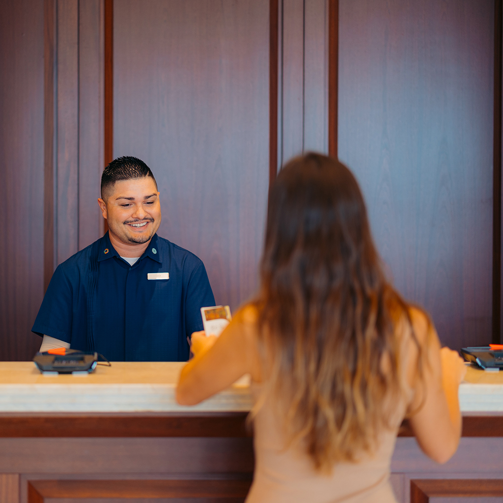 a woman talking to a male receptionist