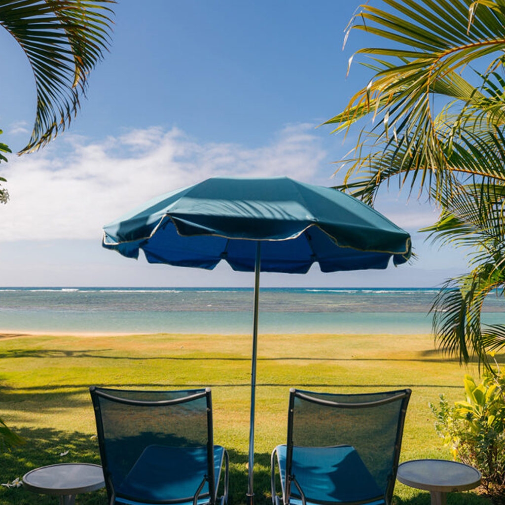 two seats and an umbrella looking out the ocean